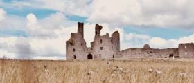 A derelict castle in a corn field.