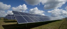 Images of solar panels in a field with a blue and white clouded sky