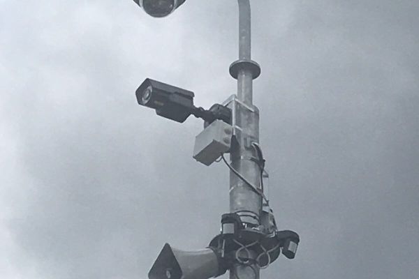 2 CCTV cameras mounted onto a pole with a speaker mounted also.