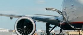 A close up shot of an aeroplane wing and engine.
