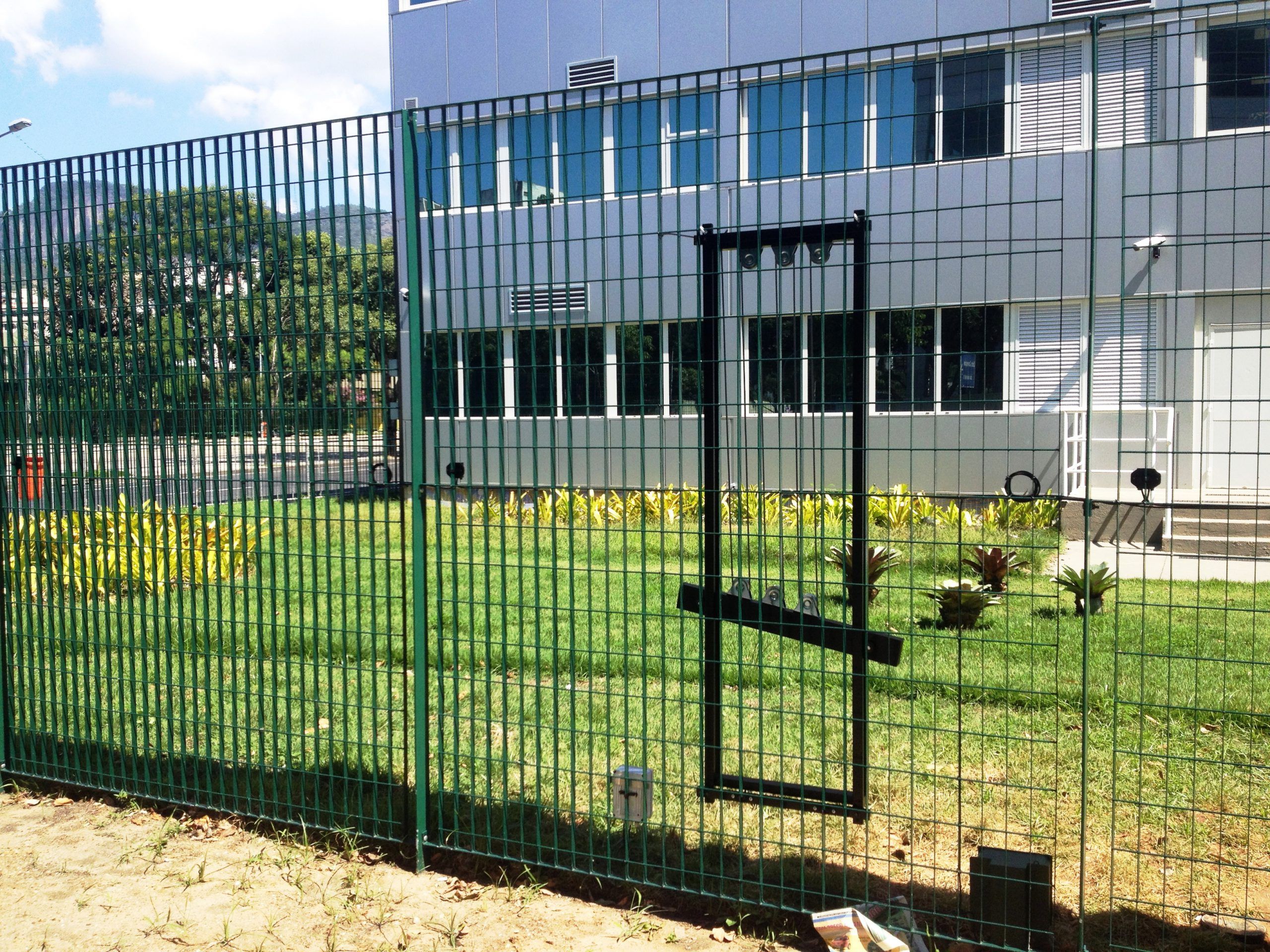A perimeter fence with a motion sensor detector kit mounted to it.