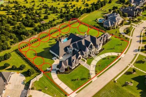 A luxury home from an aerial view with security perimeter lines.