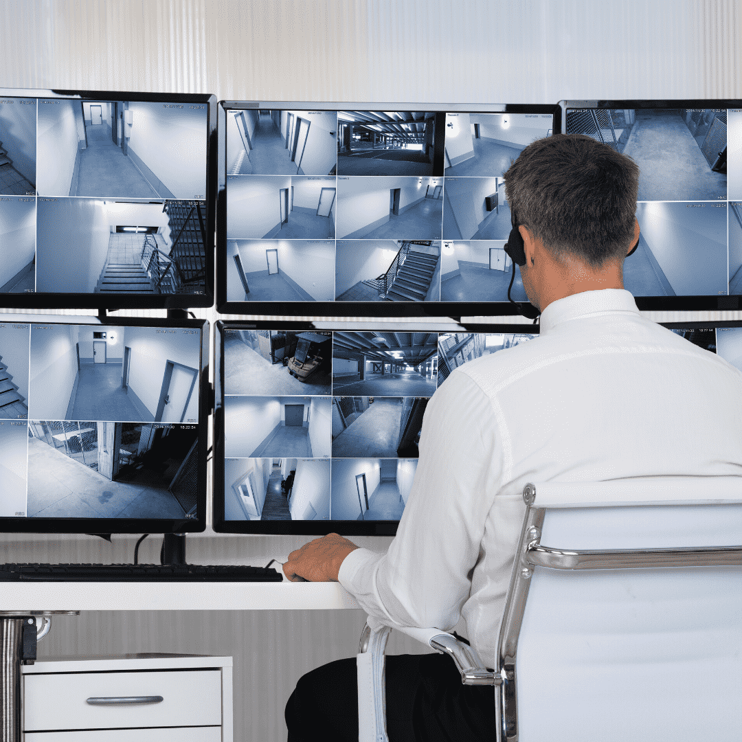 CCTV Operative sat in a chair looking at multiple cctv monitors