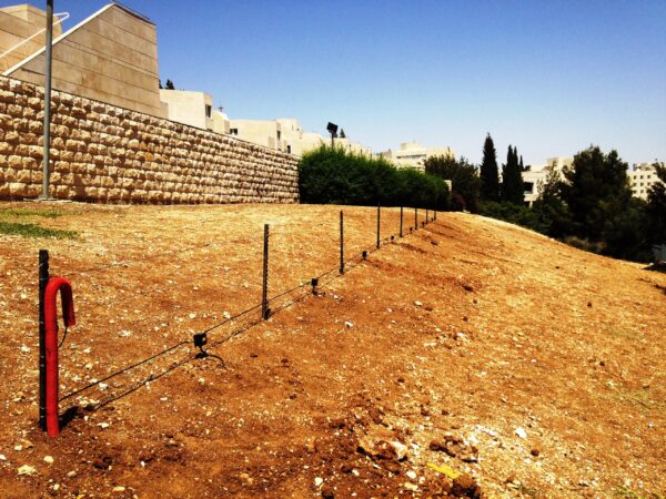 A small perimeter fence with a Tera Sens motion sensor detector kit mounted to it.