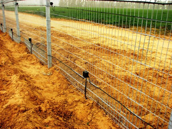A perimeter fence with a Tera Sens motion sensor detector kit mounted to it.