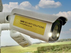 Safesitecam Smart AI Security Camera mounted on a wall in front of a landscape and clouds